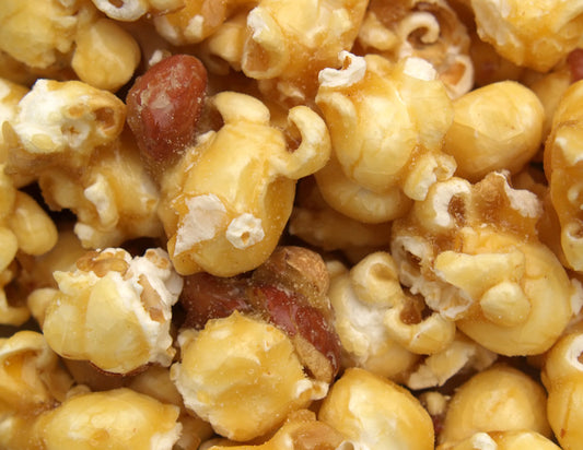 Close-up of caramel popcorn showing the texture and color of the caramel with popcorn pieces.