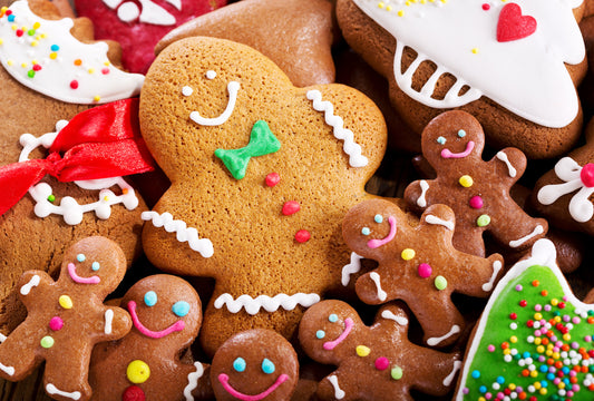 A collection of decorated gingerbread men cookies with various colorful icing and sugar decorations.